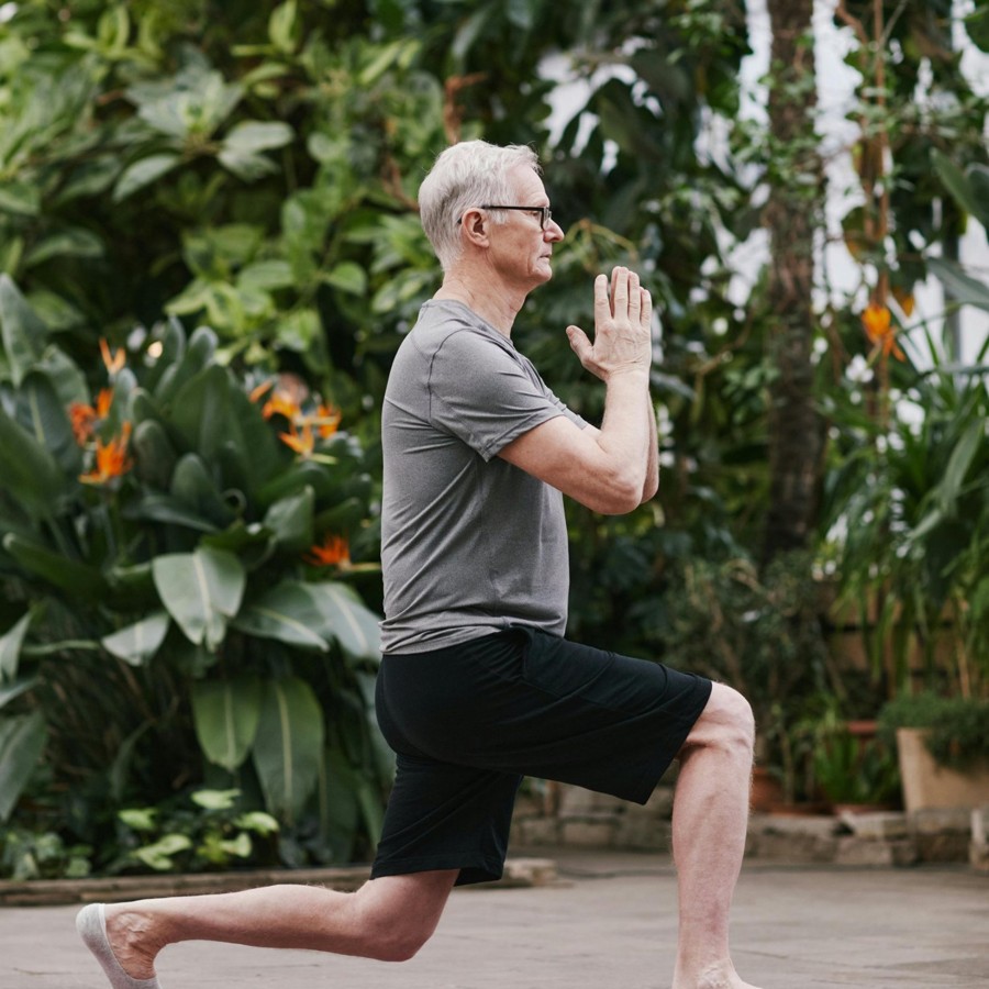 10_week2_aanpassen Week 2 aanpassen: man doet een yogaoefening tussen het groen